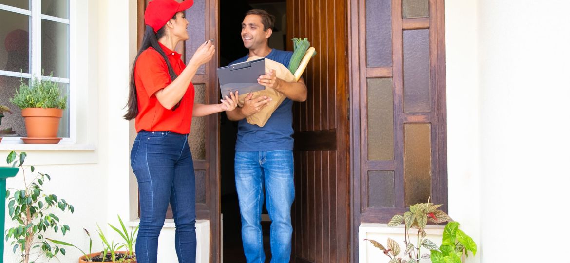 Latin postwoman holding clipboard and delivering order